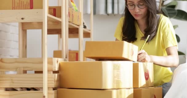 Young asian woman with child boy working and packing Thailand post box to send  ,Young business start up.  SME, Delivery Project,  - Footage, Video