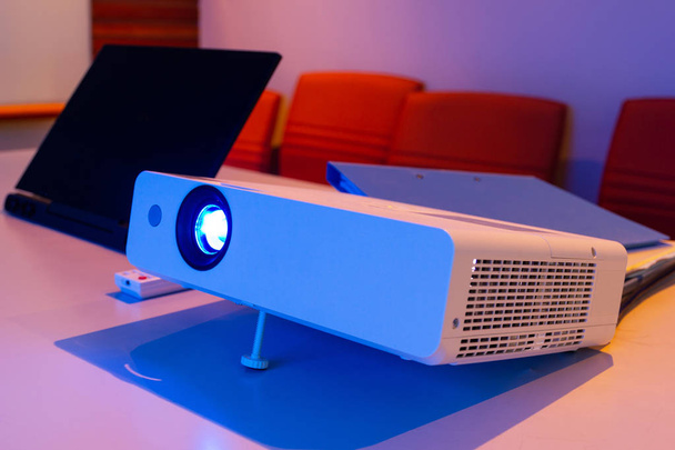 Projektor mit angeschlossenem Laptop zur Präsentation in einem Besprechungsraum mit Notebook-Hintergrund, Konzept-Besprechungsraum. - Foto, Bild