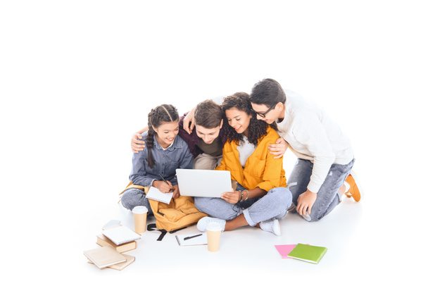 smiling multiethnic students using laptop together isolated on white - Foto, Imagem