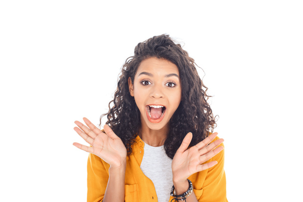 portrait of excited african american teenager with curly hair isolated on white - 写真・画像
