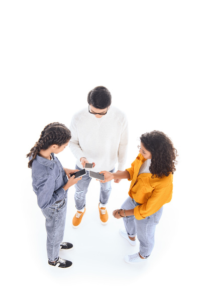 high angle view of interracial teenagers using smartphones isolated on white - Photo, Image