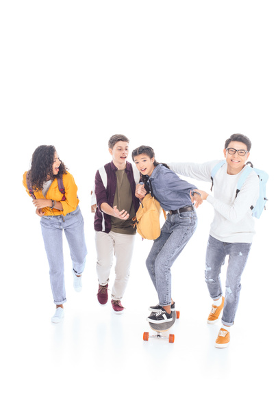 adolescents multiraciaux avec sacs à dos et planche à roulettes isolés sur blanc
 - Photo, image