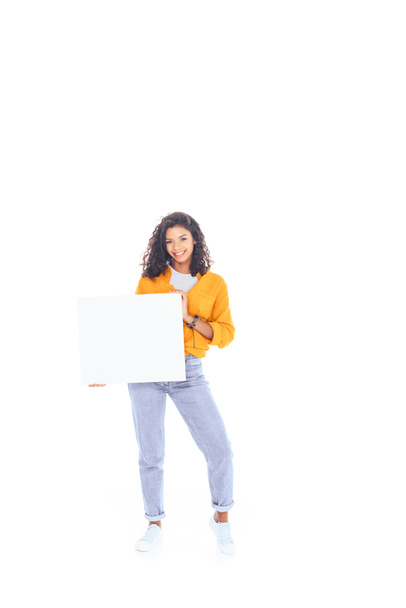 smiling african american teenager with blank banner in hands isolated on white - Zdjęcie, obraz