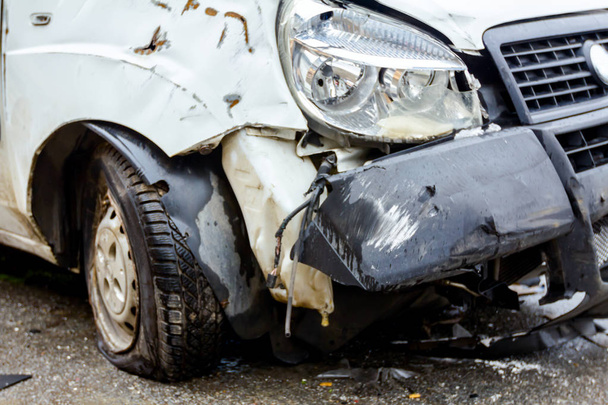 Rikkinäinen ajovalaisin valkoisessa autossa liikenneonnettomuuden jälkeen
 - Valokuva, kuva