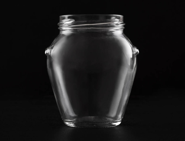 Transparent glass empty jar on a black background - Foto, Bild