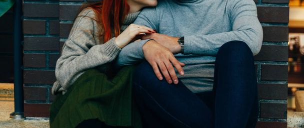 the couple is sitting on the floor in an embrace. embrace. a female hand with a ring, a man's hand with a watch. talking. gray sweaters. - Fotoğraf, Görsel