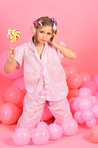 8 or 9 years old child girl eating big multicolor spiral lollipop - Foto, immagini