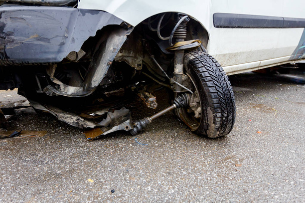 Сломанное переднее колесо на белой машине после ДТП
 - Фото, изображение
