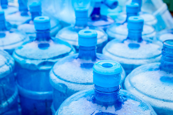 Grandes barriles de agua potable azul, botellas, galones, se moja en la lluvia
. - Foto, Imagen
