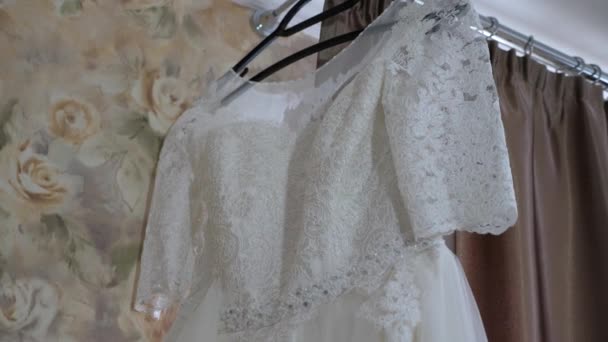 schönes weißes Hochzeitskleid hängt am Kleiderbügel am Fenster - Filmmaterial, Video