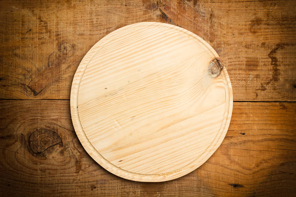 Un plato de madera vacío sobre una mesa de madera
 - Foto, imagen