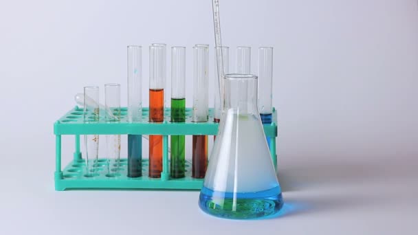 Lombikok laboratóriumi és poharak az asztalon - Felvétel, videó