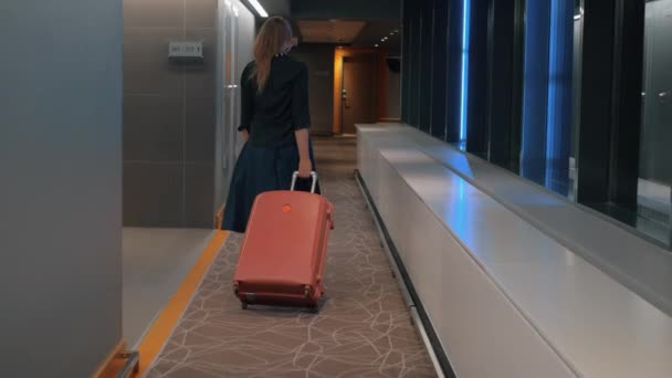 Vrouw met rolkoffer in de hal van het hotel - Video