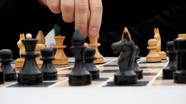 Mãos masculinas fazem um movimento em um tabuleiro de xadrez
 - Filmagem, Vídeo