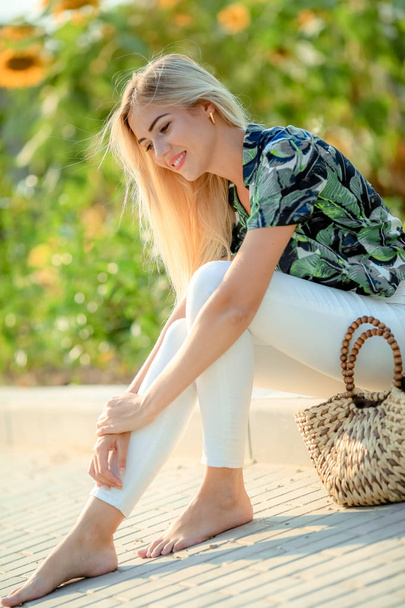 outdoor portrait of beautiful young blonde woman in white trousers and green shirt  - Φωτογραφία, εικόνα