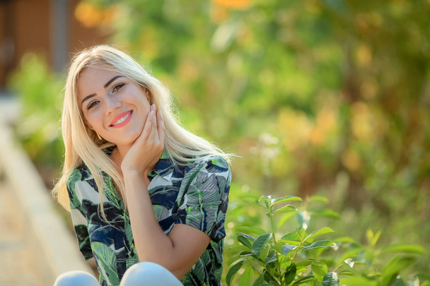 portrait of young beautiful blonde woman , sunflowers on background - Photo, image