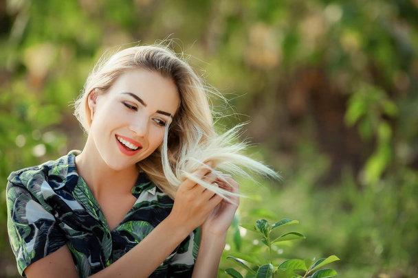 portrait of young beautiful blonde woman , sunflowers on background - Foto, Imagen