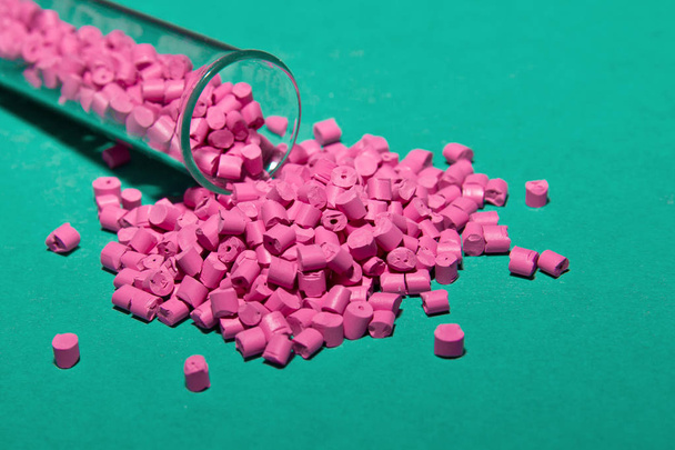 Pallet di plastica. Materie prime di plastica in granuli per l'industria. Colorante polimerico rosa su sfondo turchese. Granuli di plastica dopo la lavorazione dei rifiuti di polietilene e polipropilene.Polimero
. - Foto, immagini