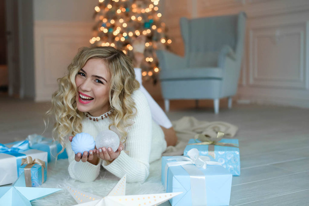   beautiful young blonde woman posing in studio with Christmas decorations  - Photo, Image