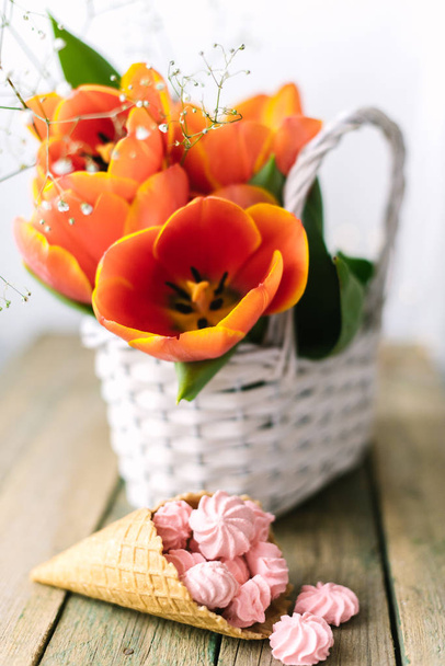 Blooming tulips near the horn with pink marshmallows - Photo, Image
