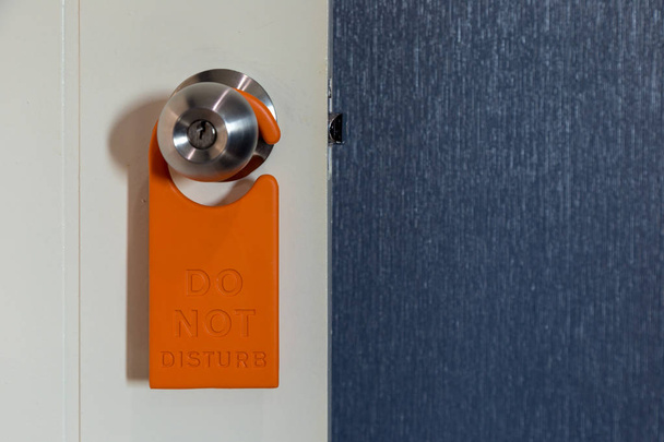 Do not disturb sign hanging at the door. - Photo, image