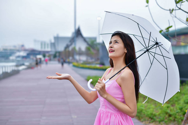 Concepto de vacaciones. Hermosa chica está sosteniendo paraguas en la playa
 - Foto, Imagen