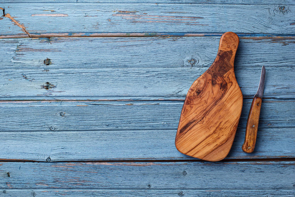 Planche à découper et couteau sur fond de bois bleu
 - Photo, image