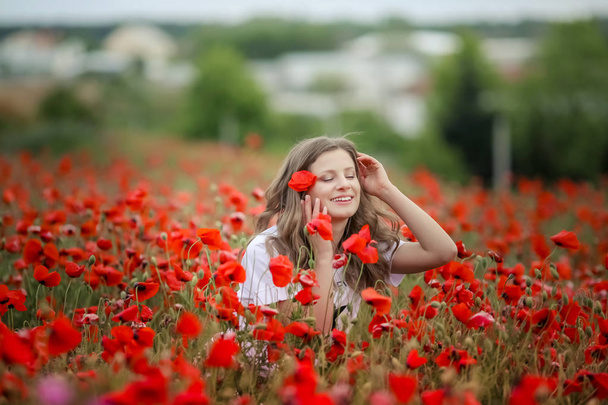 young beautiful girl posing on poppy field  - Photo, Image