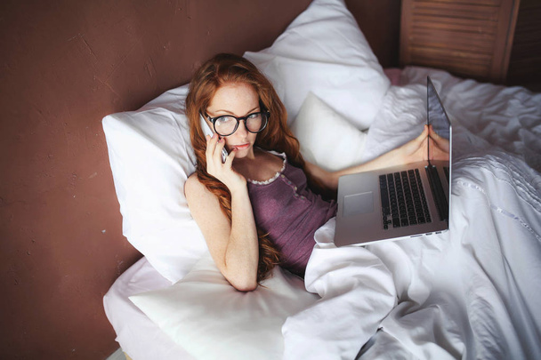 woman using laptop while lying in bed  - Valokuva, kuva