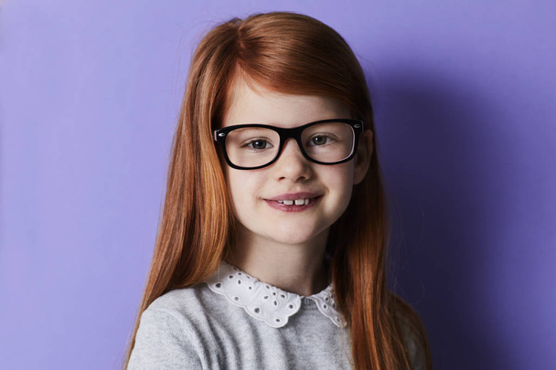 Happy redheaded girl in glasses looking at camera, portrait - Foto, imagen