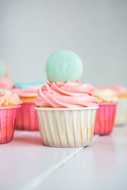 Sweet cupcakes with cream, decorated gingerbread, beads and makarons for gentle refined girl or a little princess. Cupcakes in pink, turquoise and cream color. - Foto, Imagen