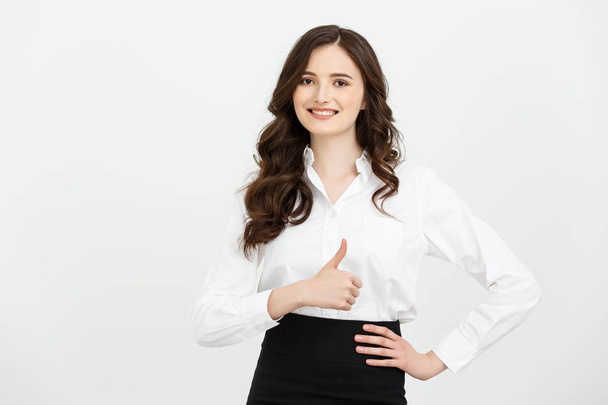 Business Concept: Confident young cheerful woman showing thumb up. Isolated over grey copy space background. - Photo, Image