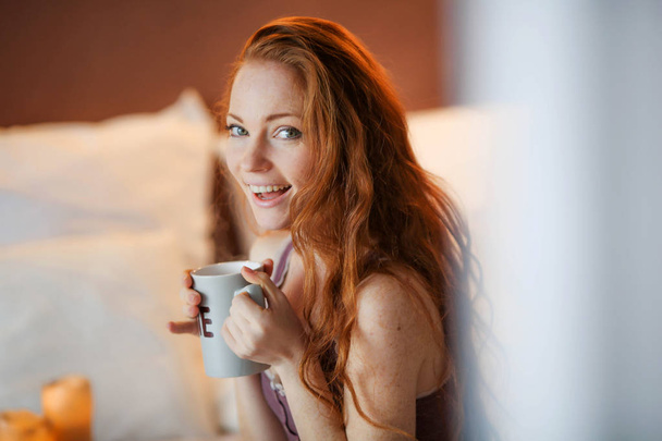 beautiful red haired woman drinking coffee  - Fotoğraf, Görsel