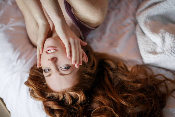 close up portrait of beautiful red haired woman lying in bed  - Fotoğraf, Görsel