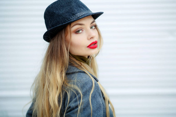 outdoor portrait of beautiful blonde woman wearing grey hat and coat  - Photo, Image