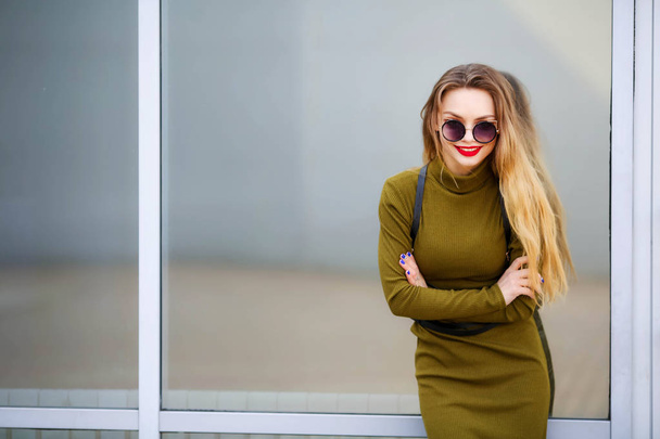 young beautiful woman posing outdoors wearing green dress - Foto, Imagen