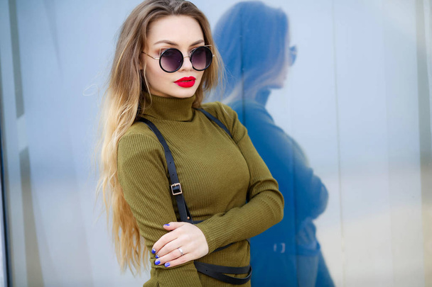 young beautiful woman posing outdoors wearing green dress and sunglasses  - Photo, Image