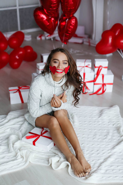 woman posing in studio with gift boxes and balloons. Valentines day concept  - Фото, изображение