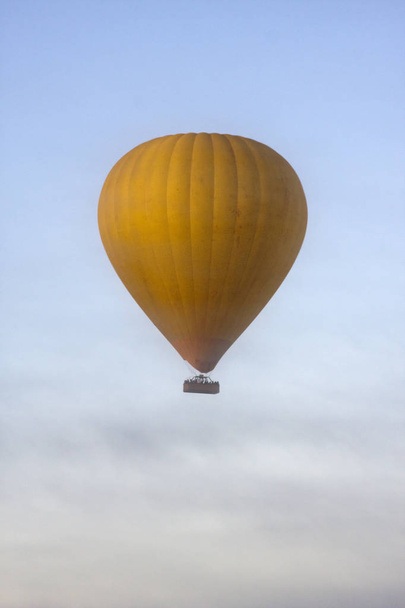 Keltainen kuumailmapallo pilvissä
 - Valokuva, kuva