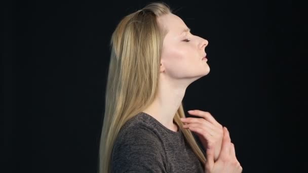 emotionele portret van een blond meisje op een zwarte achtergrond - Video