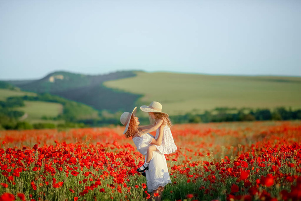 mother and daughter posing on poppy field - Foto, Bild
