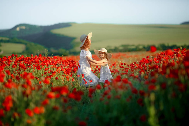 mother and daughter posing on poppy field - Fotó, kép