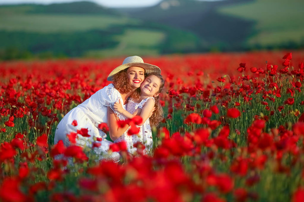 mother and daughter posing on poppy field - 写真・画像