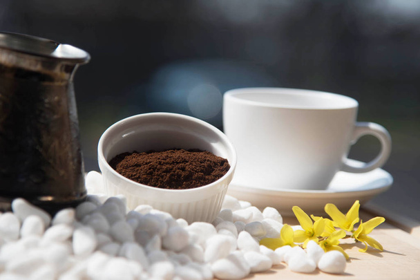 Turkse koffiepot en een kopje koffie op witte stenen - Foto, afbeelding