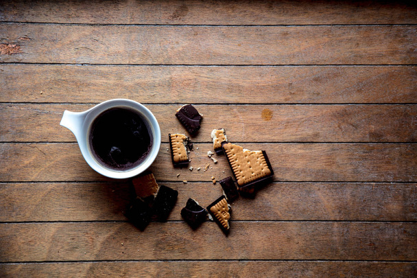 Біла чашка з кавою та печивом
 - Фото, зображення