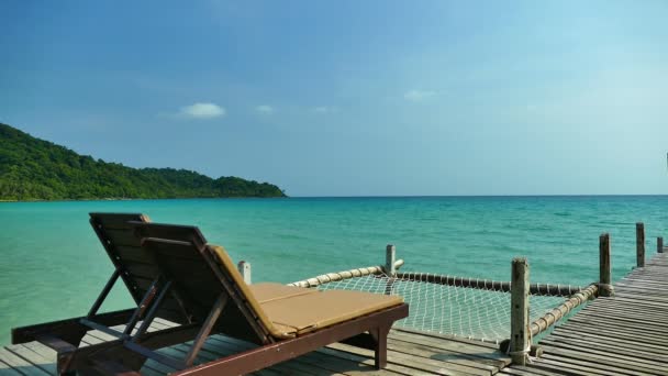 due chaise longue sul molo di legno sulla spiaggia tropicale
  - Filmati, video