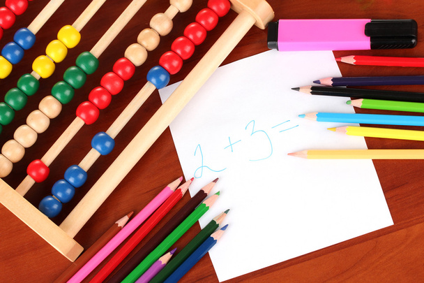 Toy abacus, note paper, pencils on bright background - Φωτογραφία, εικόνα