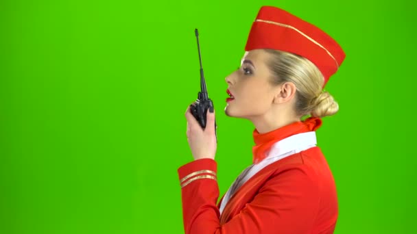 Stewardessa mówi na walkie talkie. Zielony ekran. Widok z boku - Materiał filmowy, wideo