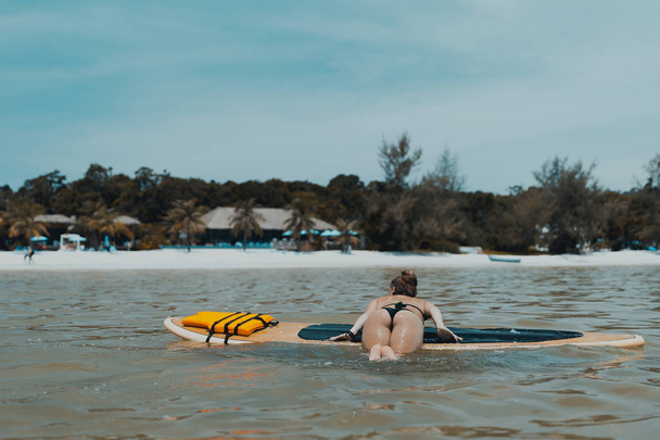 パドル ボードで泳いでいるセクシーな少女。島栄 Samloem。サラセン湾、カンボジア.  - 写真・画像