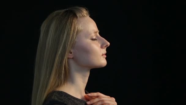 συναισθηματική πορτρέτο του ένα ξανθό κορίτσι με ένα μαύρο φόντο - Πλάνα, βίντεο